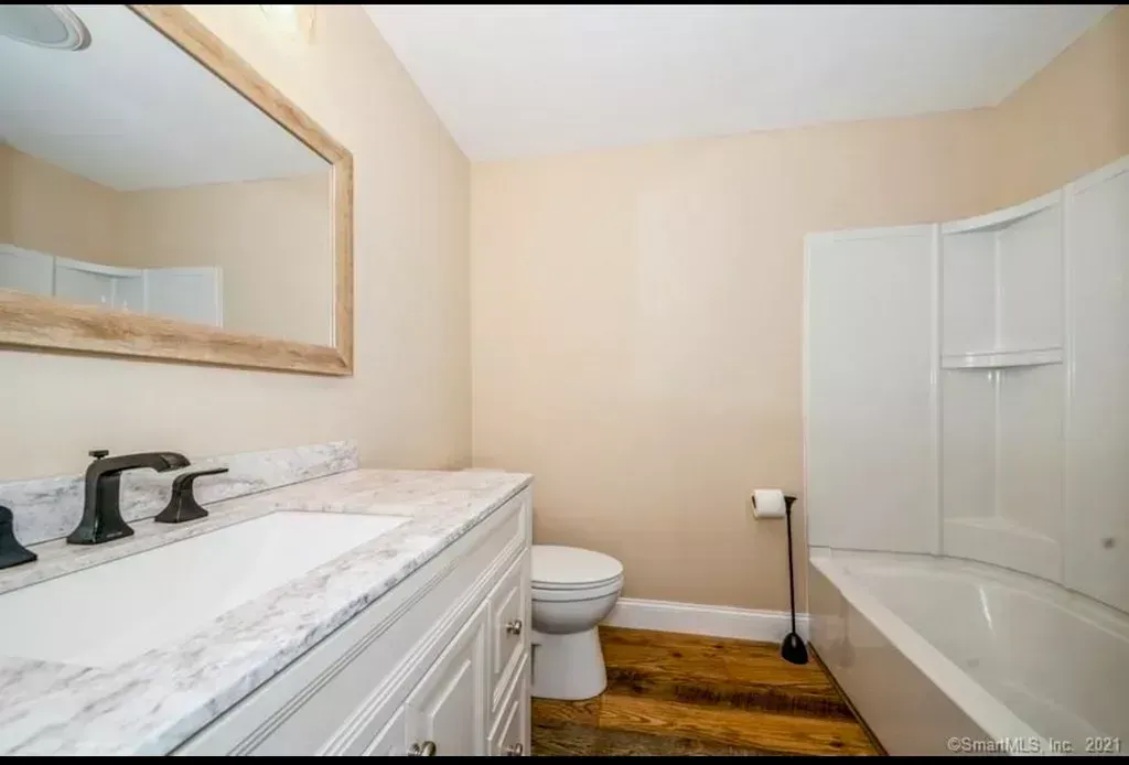 A bathroom with a toilet , sink and bathtub