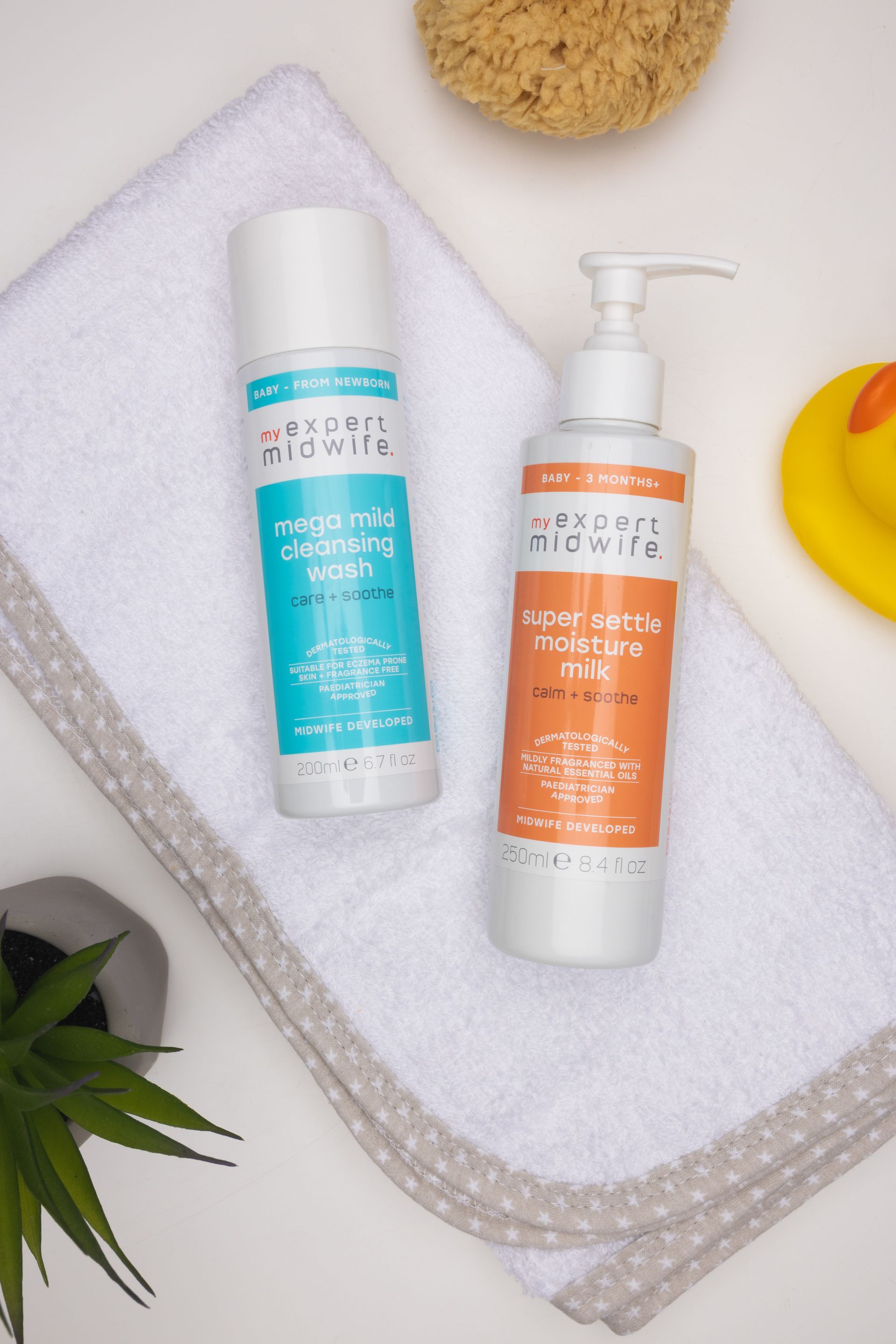 two bottles of shampoo and conditioner are sitting on a towel .