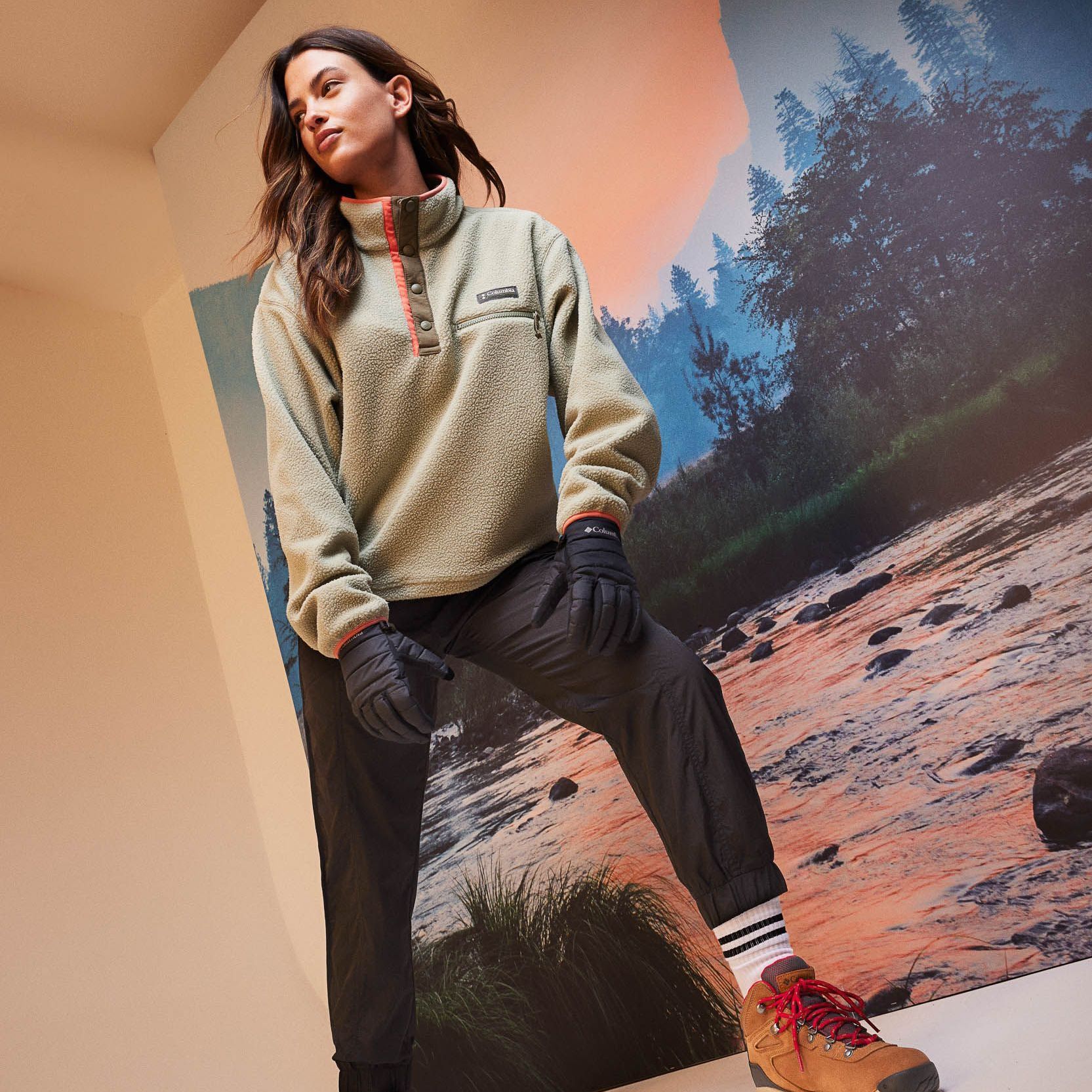 a woman is standing in front of a picture of a river .