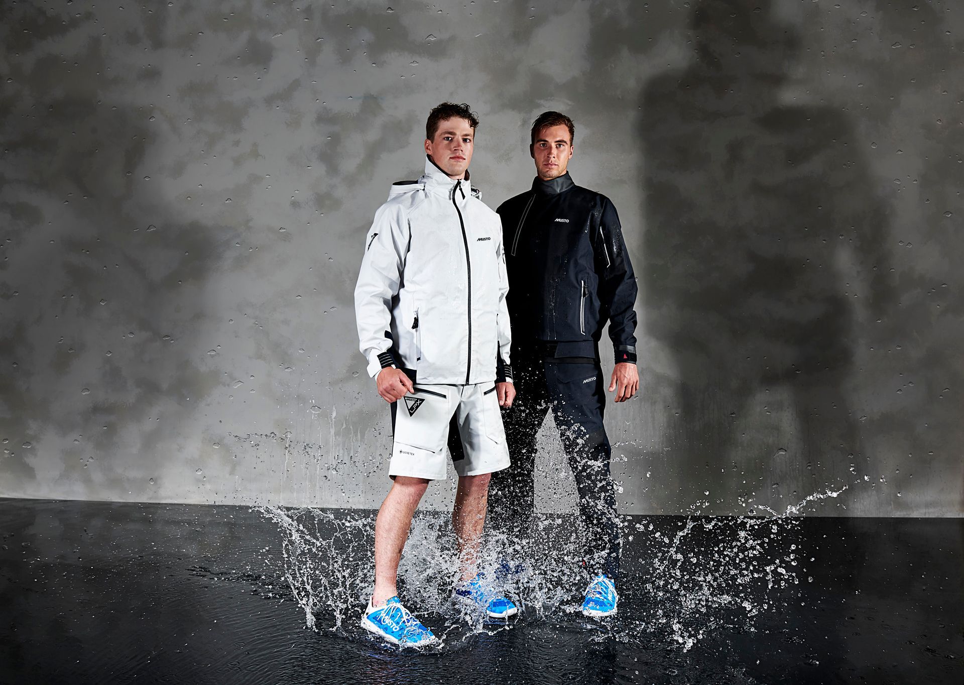 two men are standing next to each other in a puddle of water .