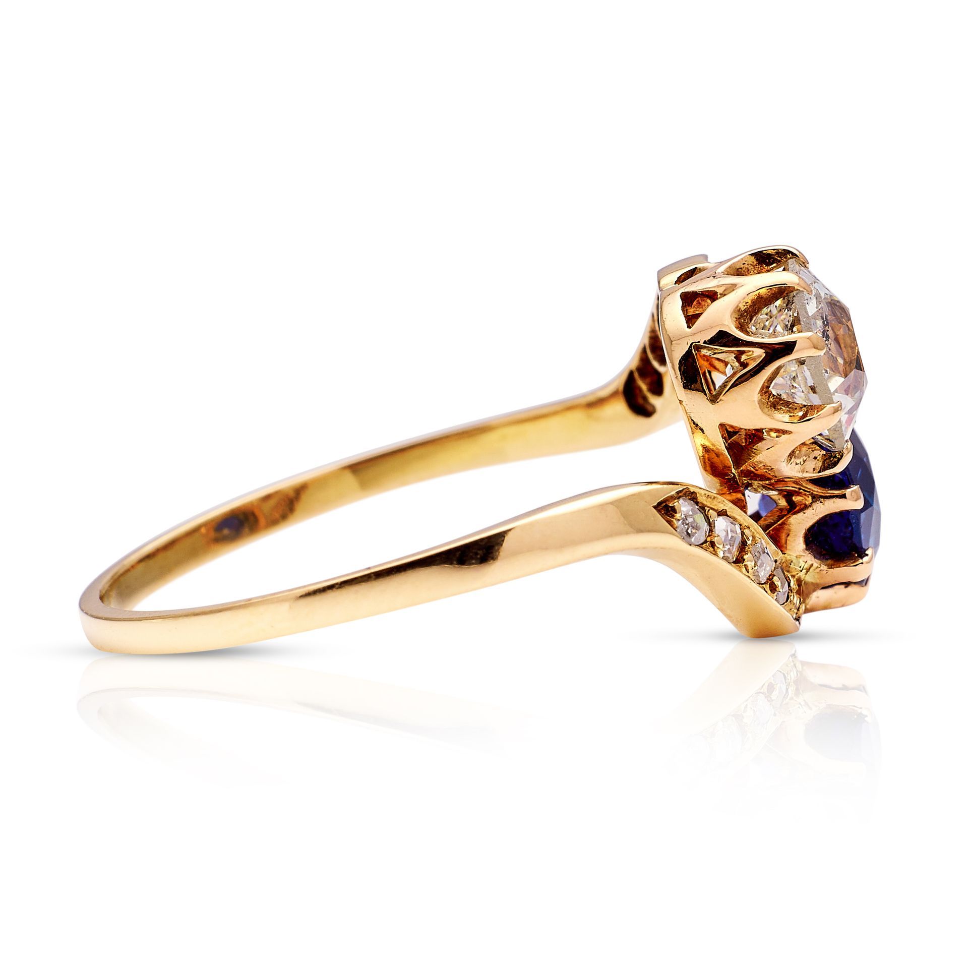 a gold ring with a sapphire and diamonds on a white background