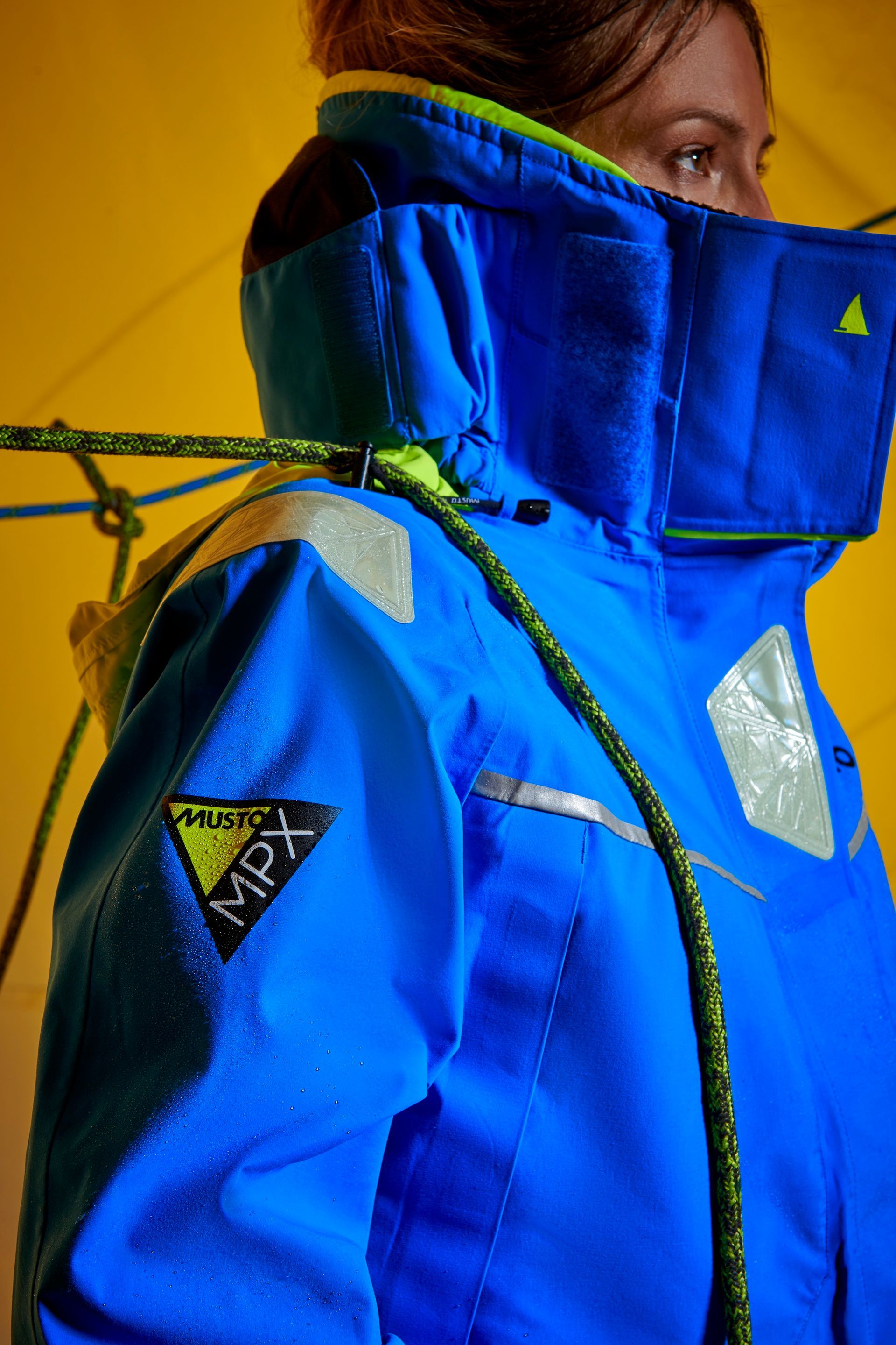 a woman wearing a blue jacket with a mpx logo on it