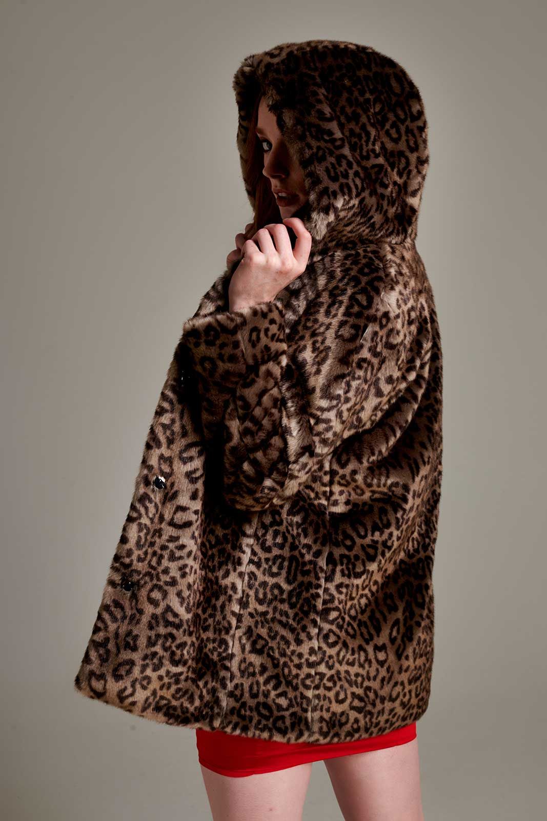 a woman wearing a leopard print fur coat with a hood