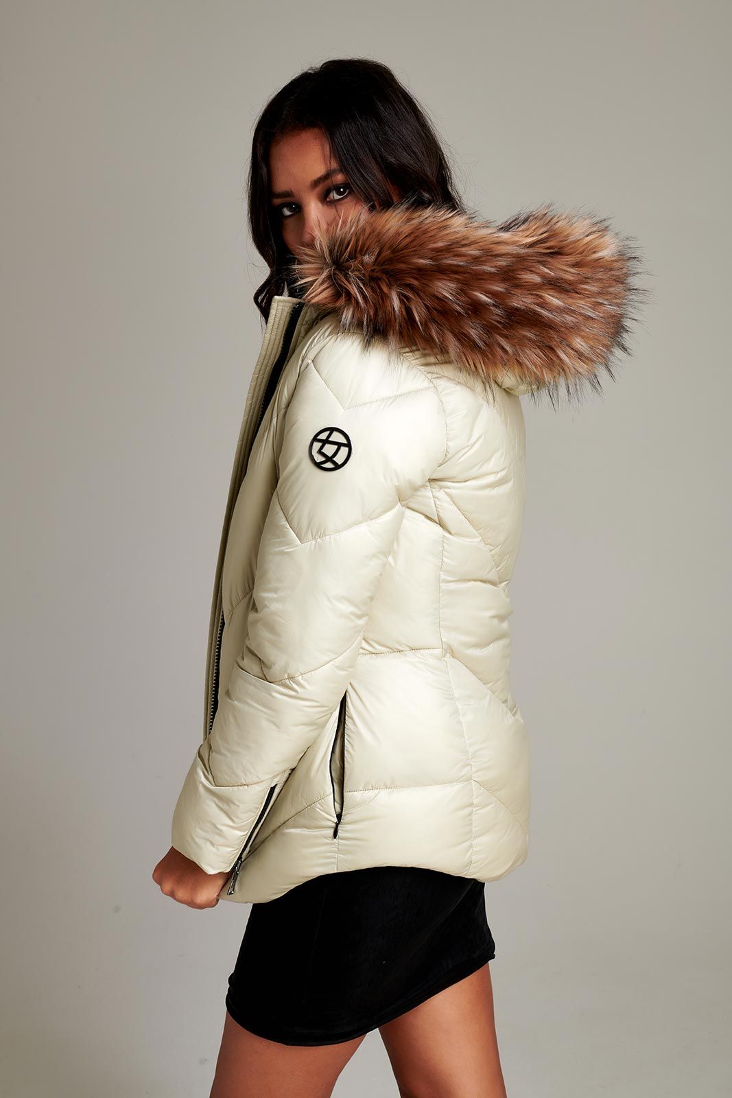 a woman is wearing a white jacket with a fur hood .