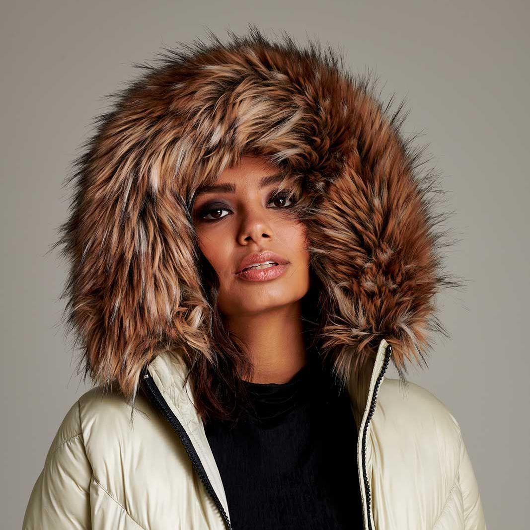 a woman wearing a white jacket with a fur hood