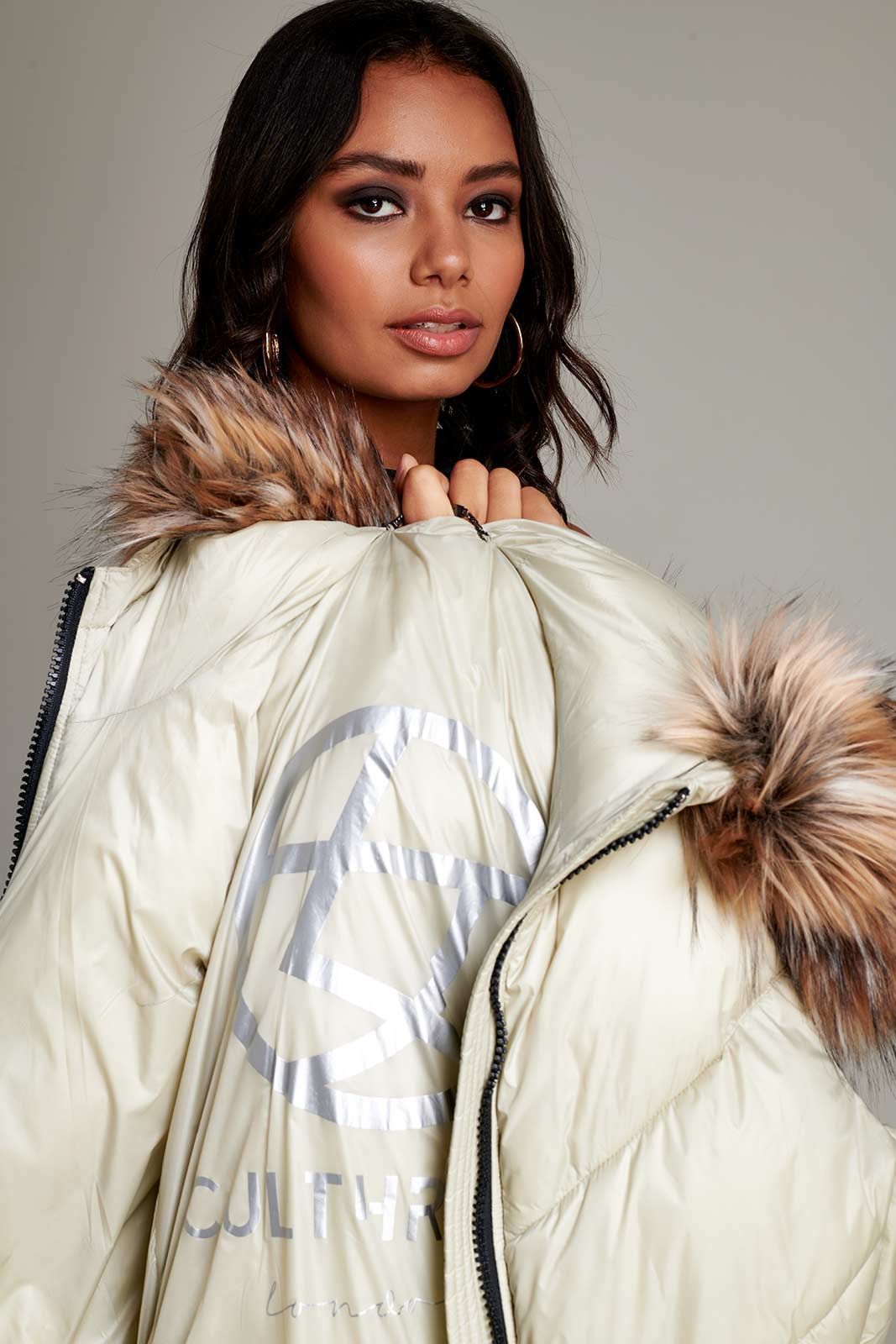 a woman is wearing a white jacket with a fur hood .