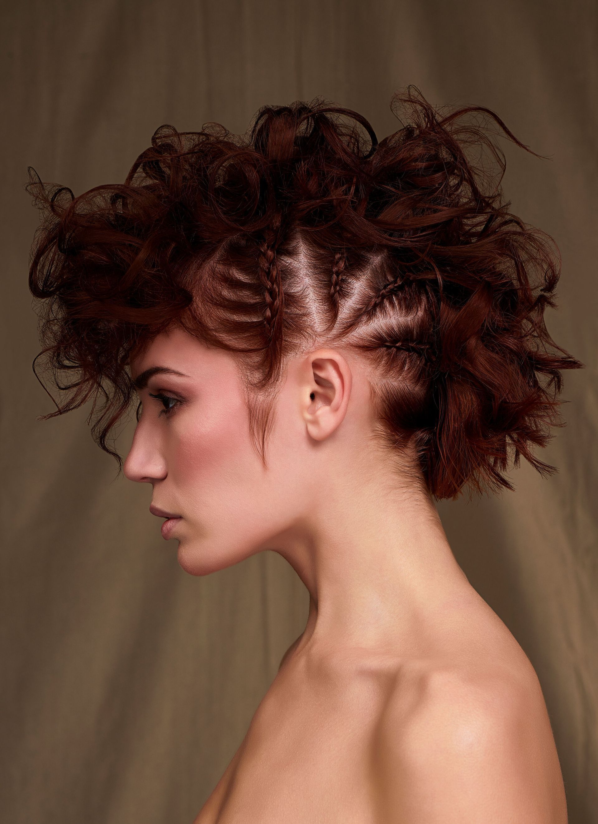 A woman with curly hair and a mohawk hairstyle