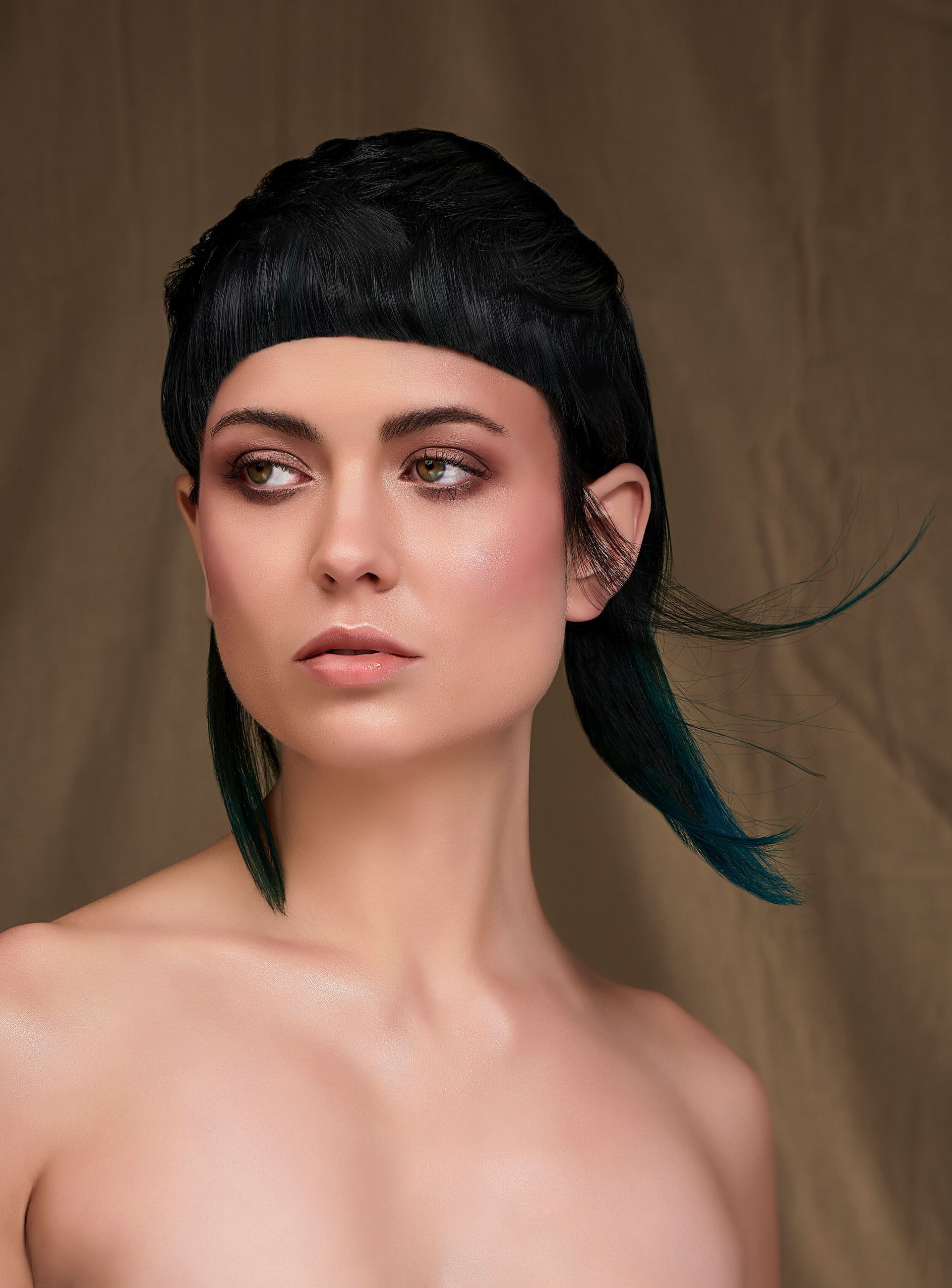 A woman without a shirt is wearing a black hat and blue hair.
