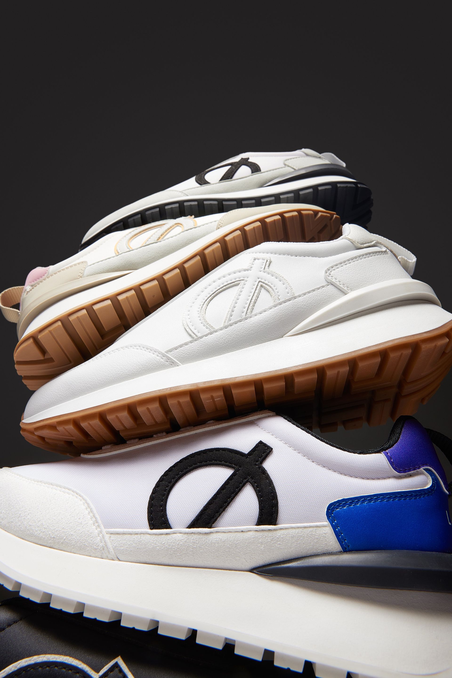 a stack of white sneakers with a black circle on the side .