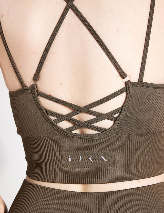 the back of a woman wearing a brown sports bra