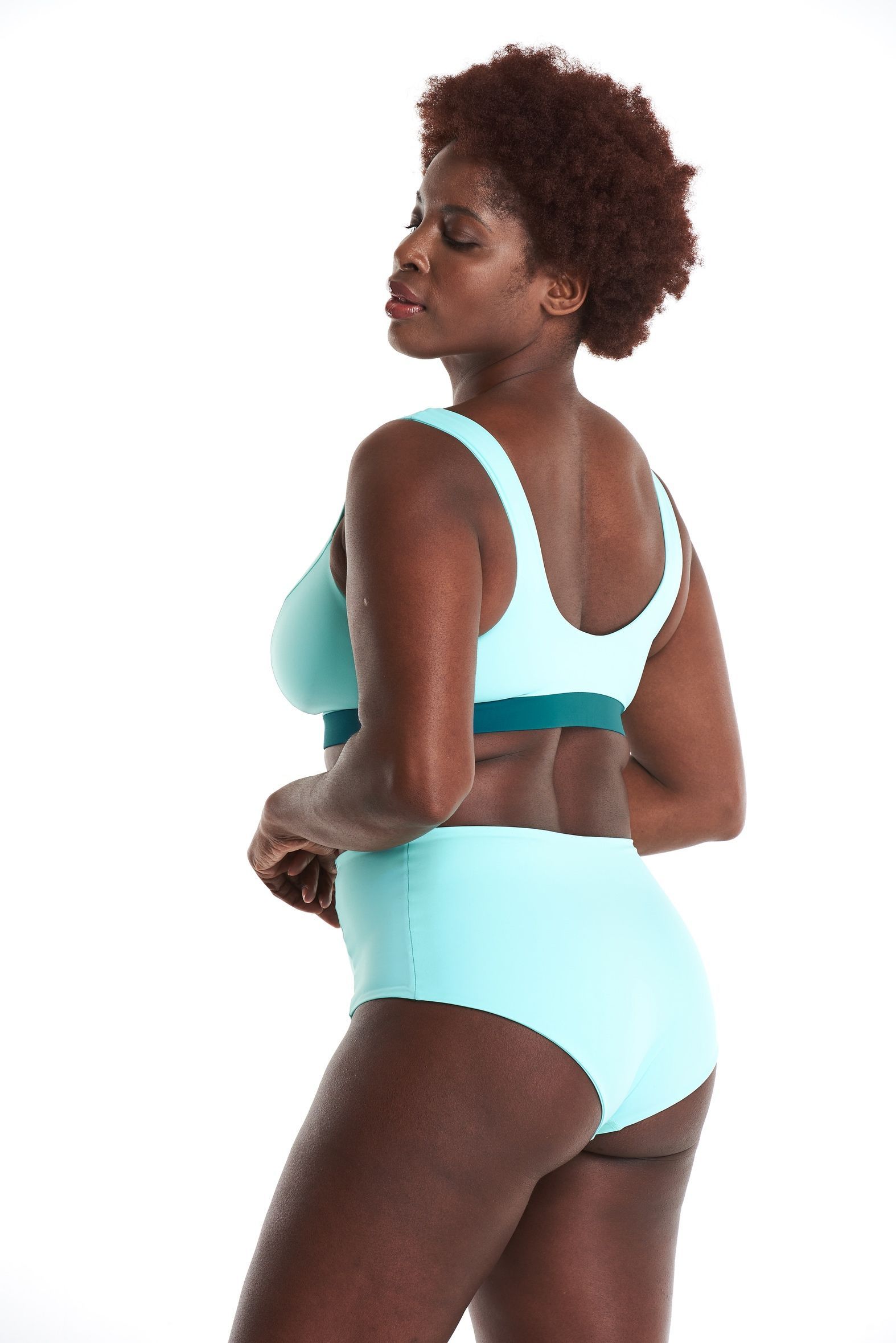 a woman in a blue bikini is standing on a white background .
