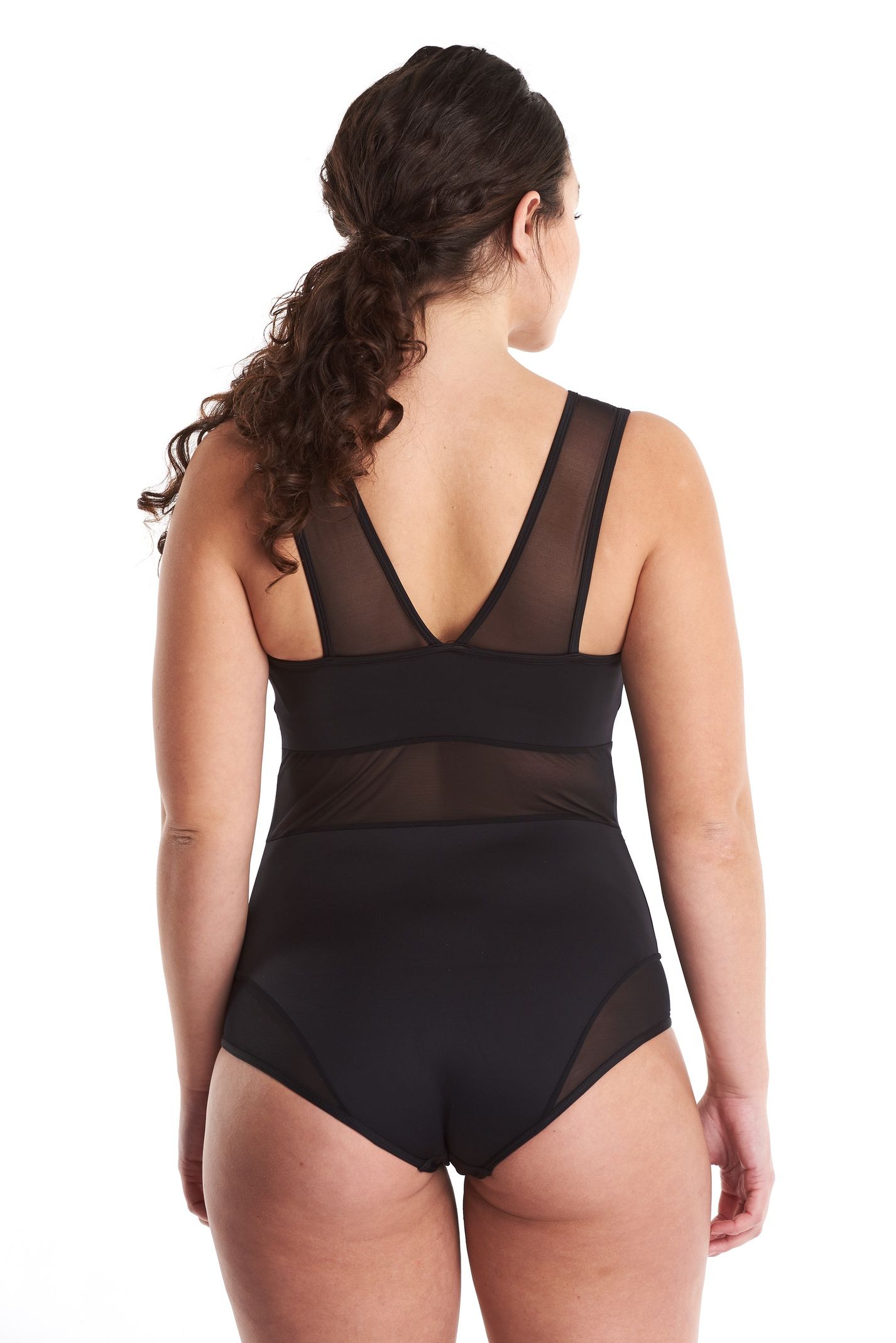 a woman in a black bodysuit is standing on a white background .