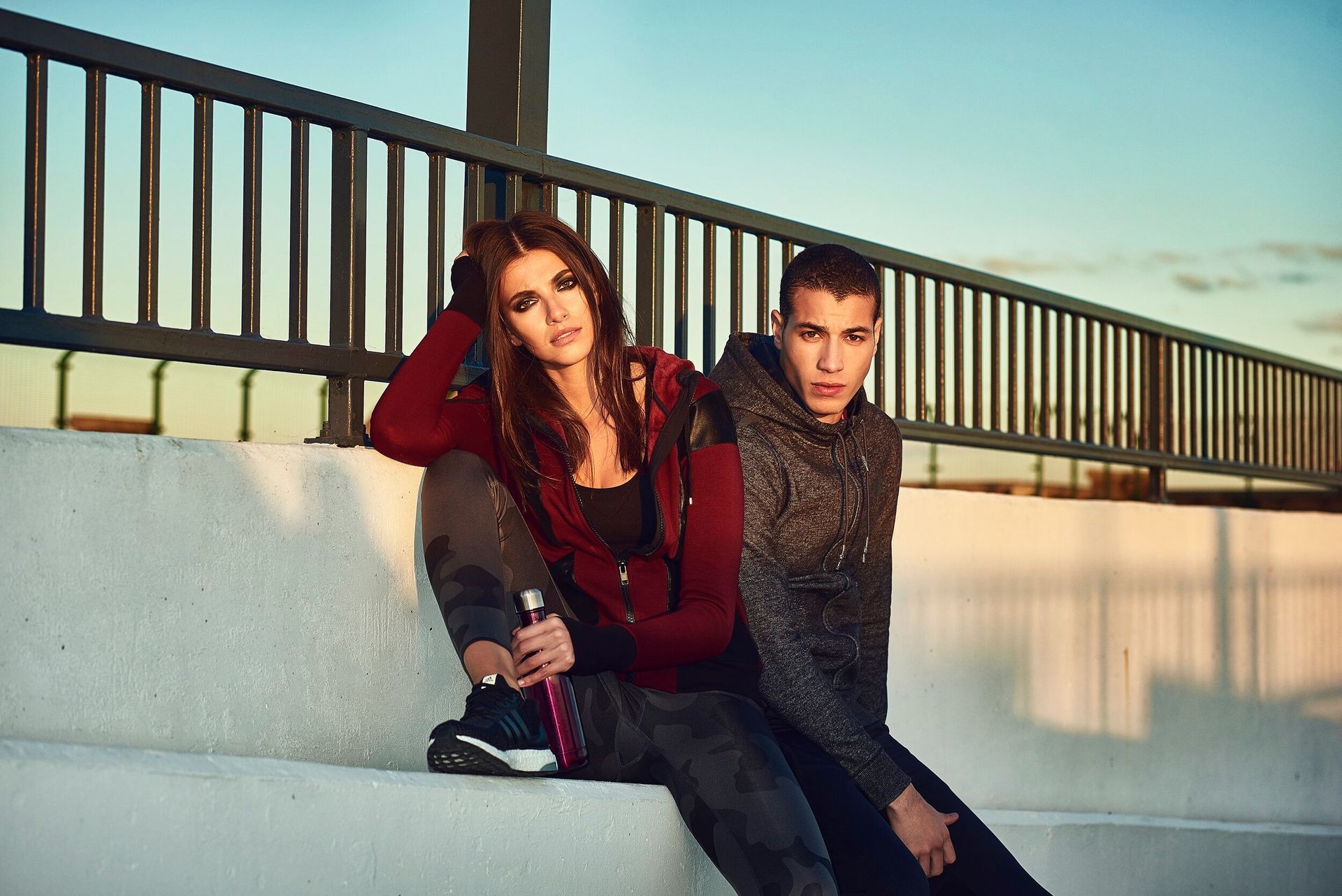A man and a woman are sitting next to each other on a bench.