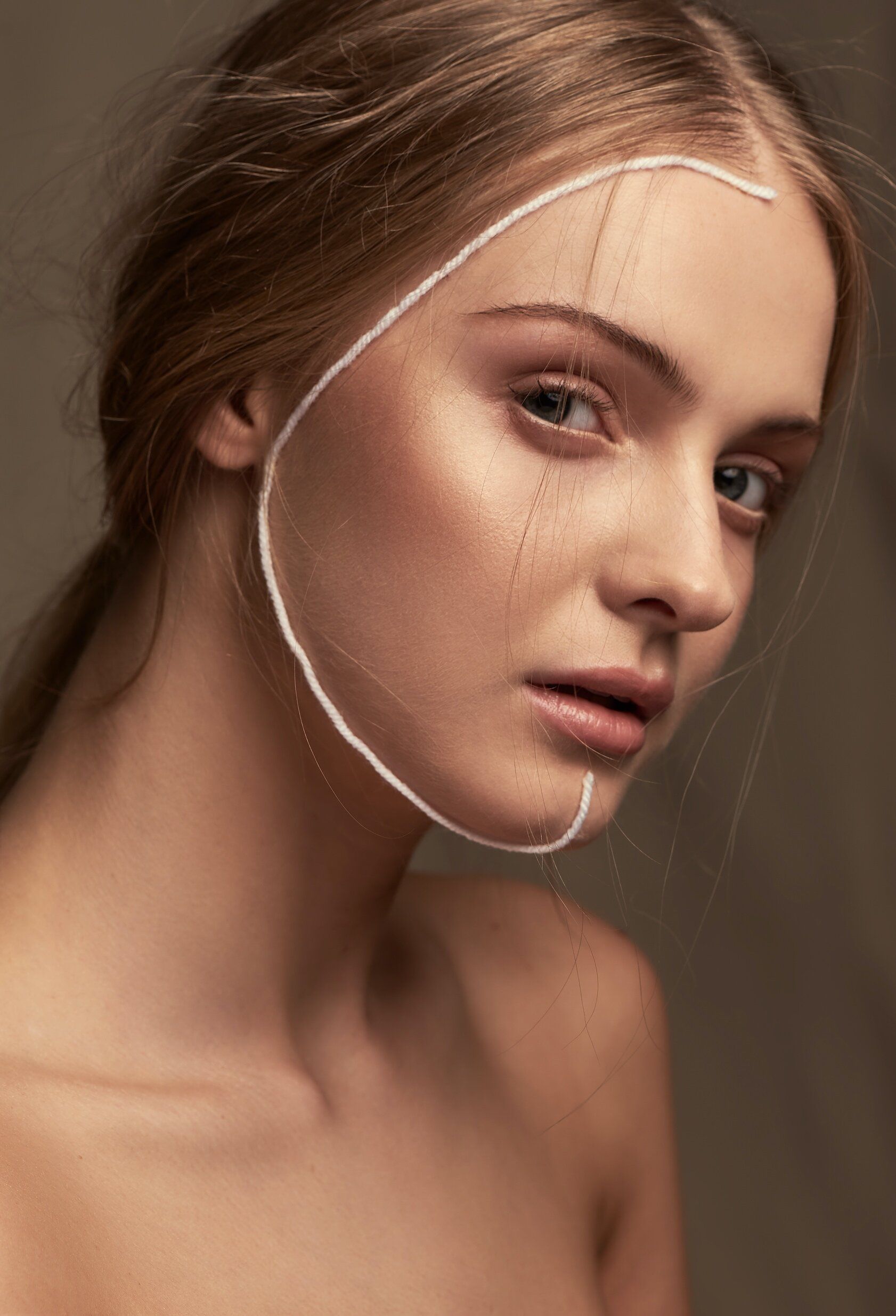 A close up of a woman 's face with a white line drawn on it.