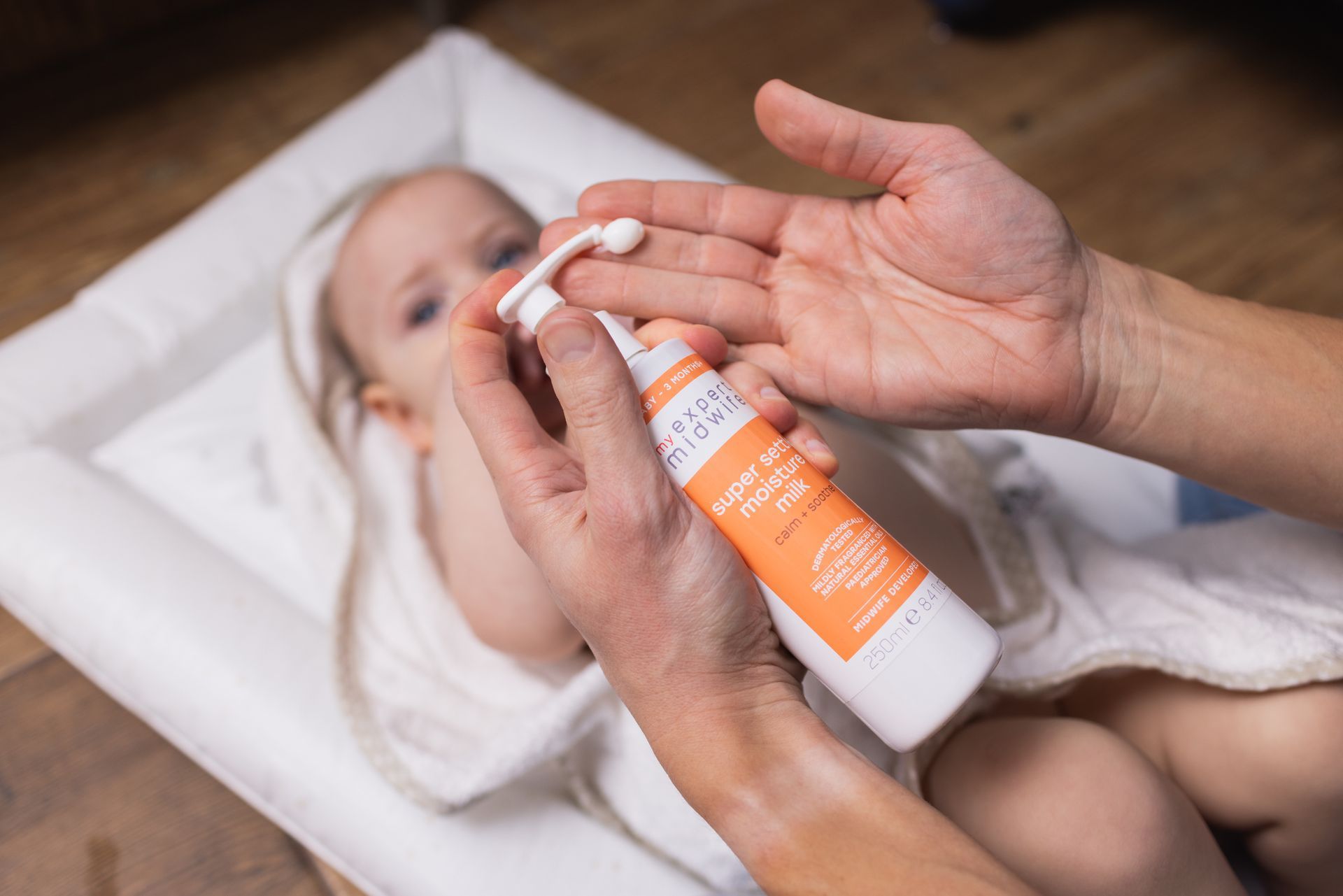 a person is applying lotion to a baby 's hand .