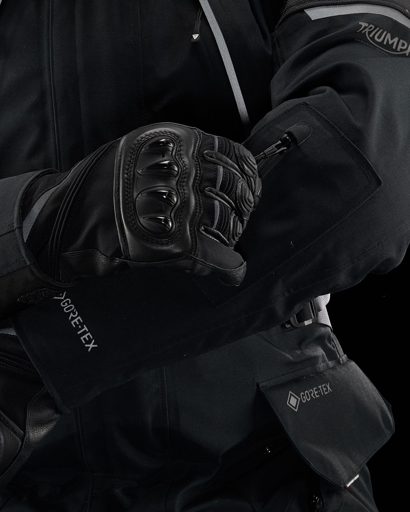a person wearing a black jacket and black gloves .