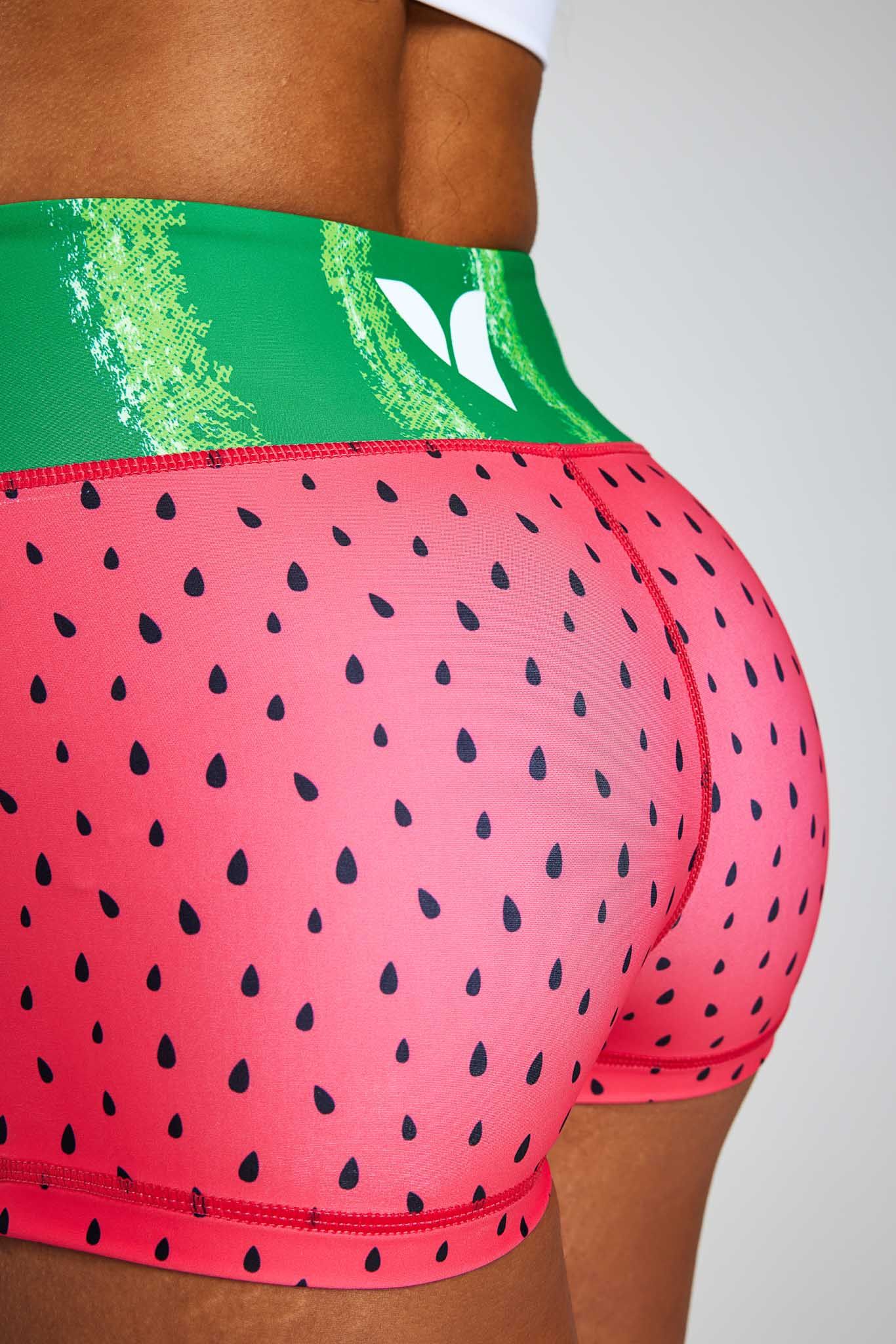 a woman is wearing a pair of watermelon shorts with a green waistband .