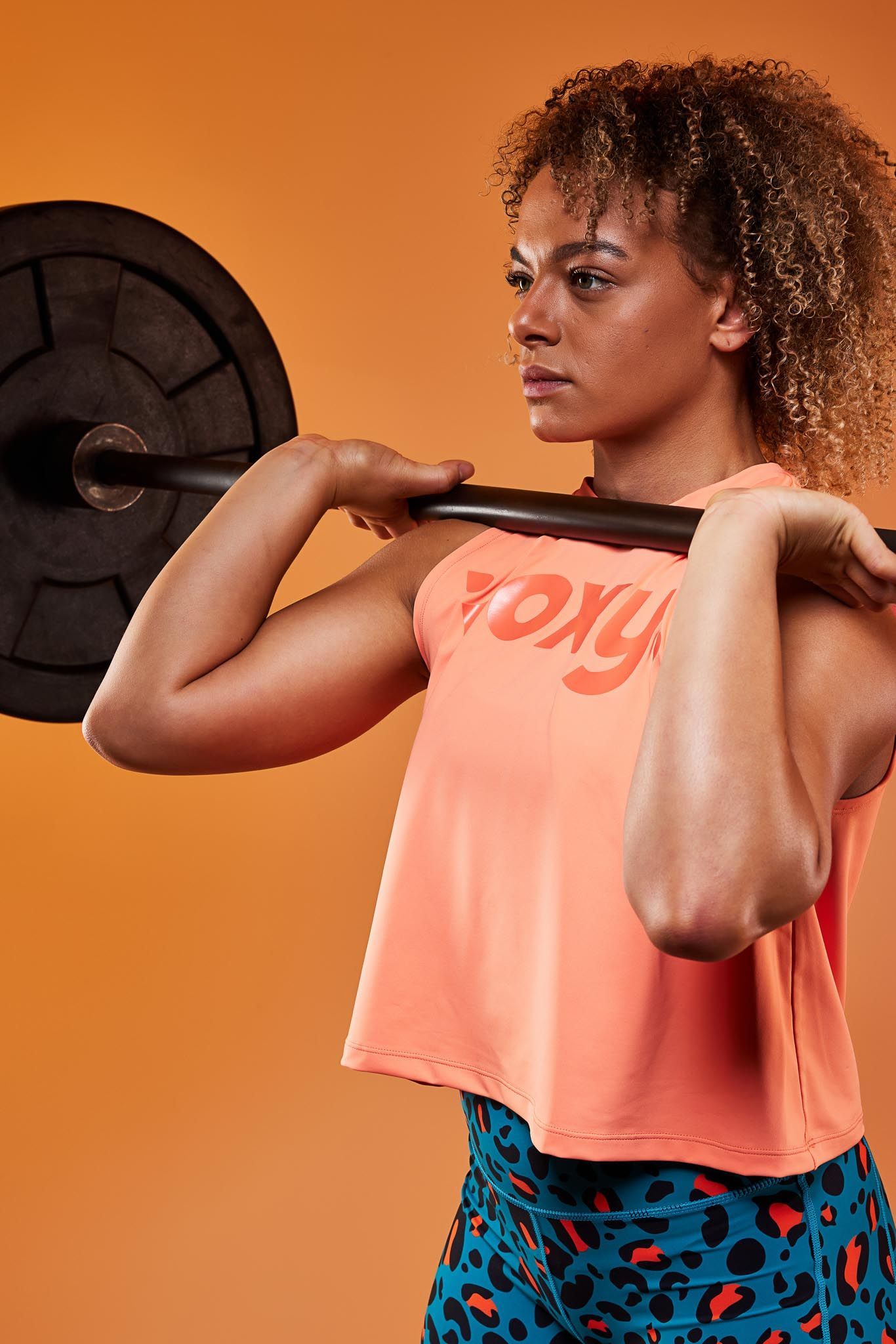 A woman is lifting a barbell over her head.