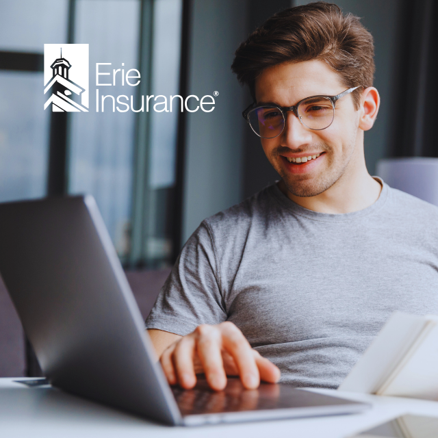 Man smiling at laptop, Erie Insurance logo in corner.