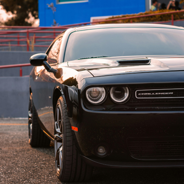 Black Dodge Challenger car parked, close-up of front.