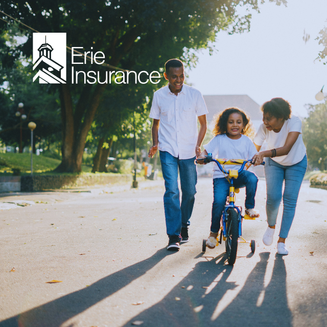 Family teaching child to ride a bike on a sunny path, Erie Insurance logo in the corner.