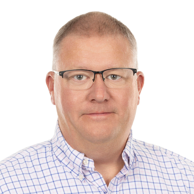 Man with glasses, wearing a light blue and white checked shirt, against a white background.
