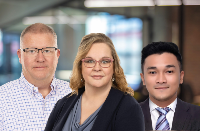 Three professionals posing for a photo in an office setting.