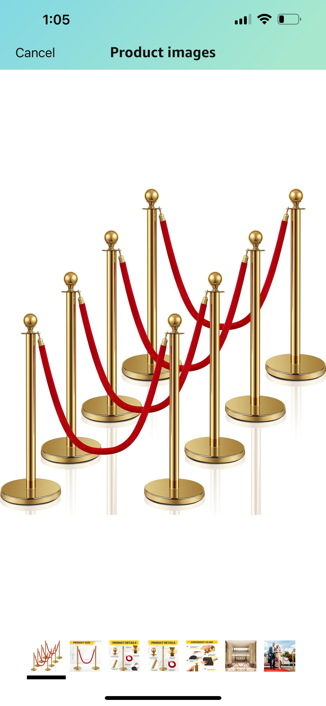A row of gold poles with red ropes attached to them.