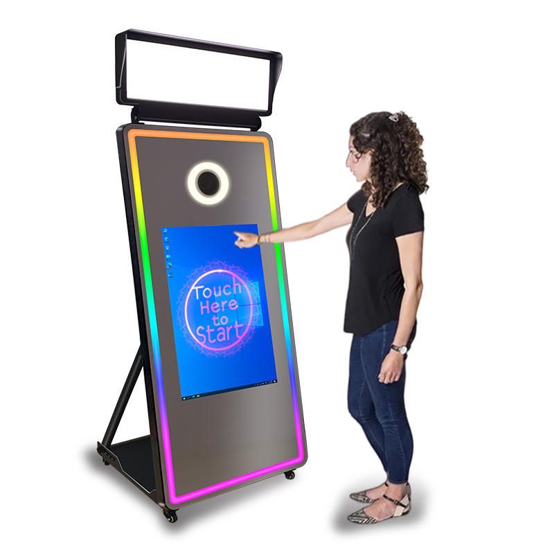 A woman is standing in front of a mirror that says `` touch here to start ''.