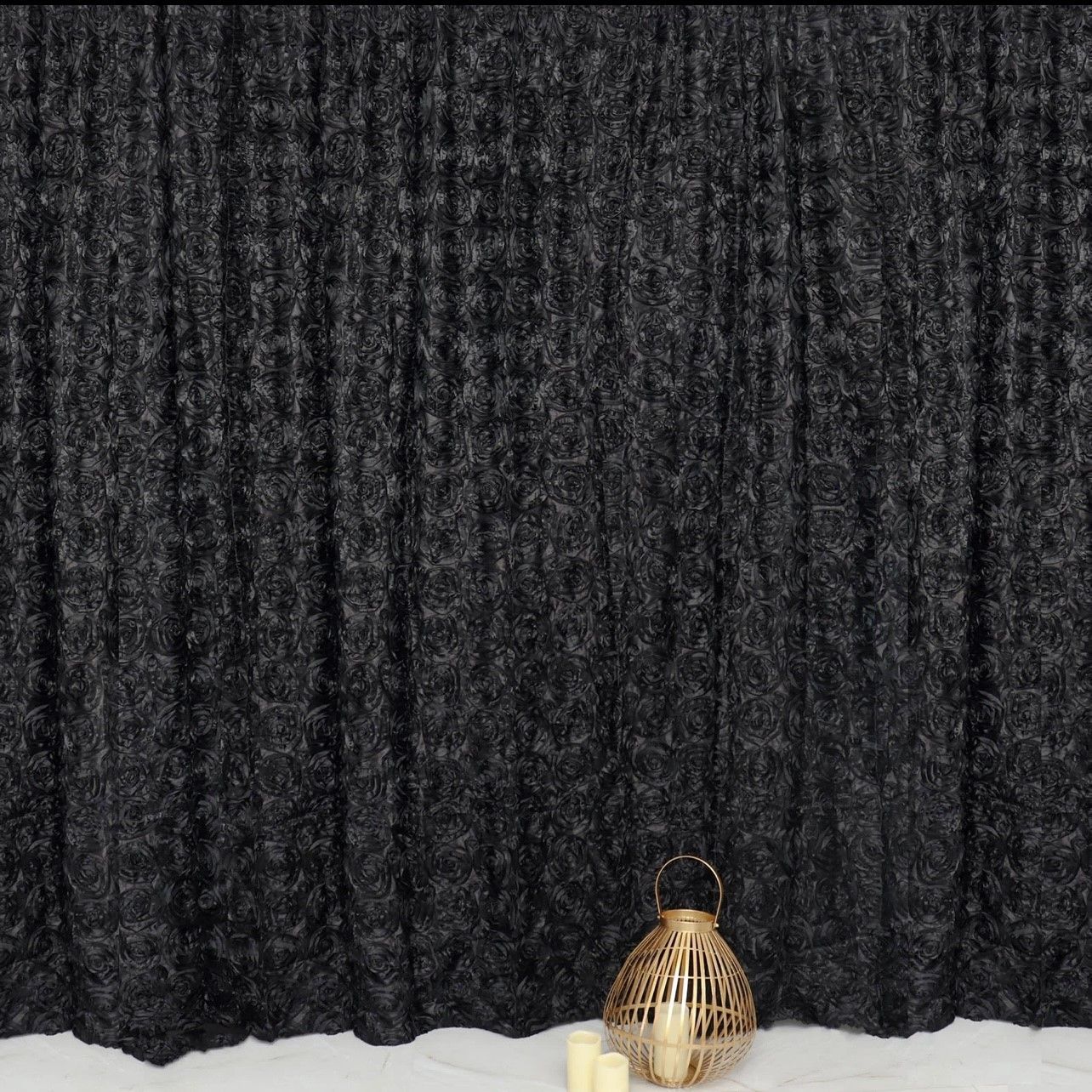 Black, textured backdrop with a gold lantern and candles at the bottom, creating a dim, moody atmosphere.