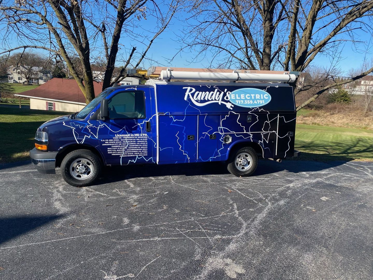A handy 's electric van is parked in a parking lot.
