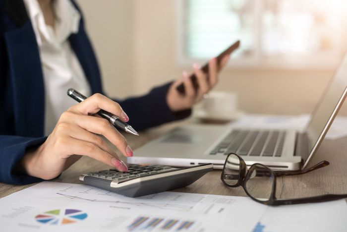 Woman Using A Calculator — Jodie Nielsen Cost Segregation Service, Inc. — Nationwide Woman Using A Calculator — Jodie Nielsen Cost Segregation Service, Inc. — Nationwide