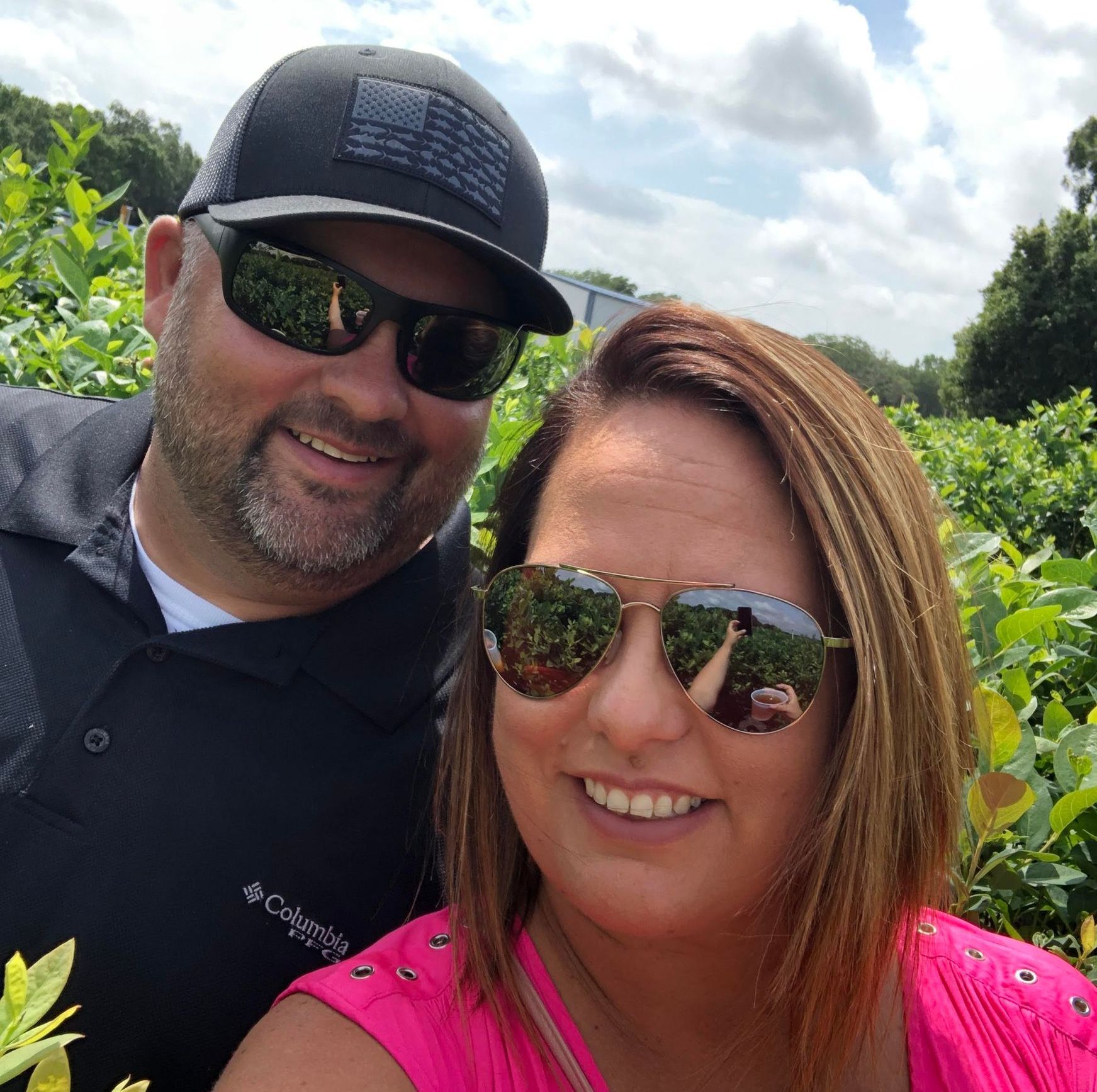 A man and a woman wearing sunglasses are posing for a picture