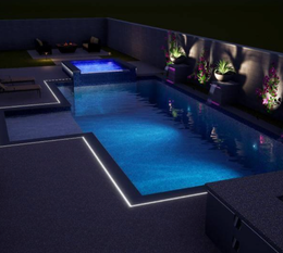 A large swimming pool is lit up at night