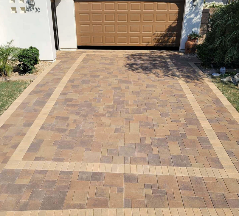 A brick driveway leads to a garage with a brown door