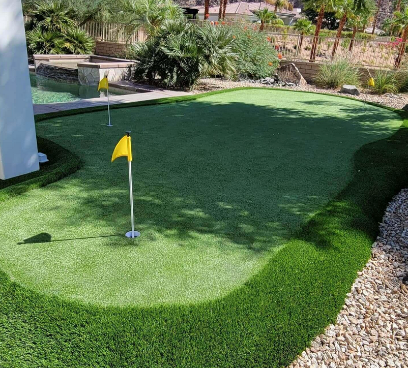 A golf course with a yellow flag on the green