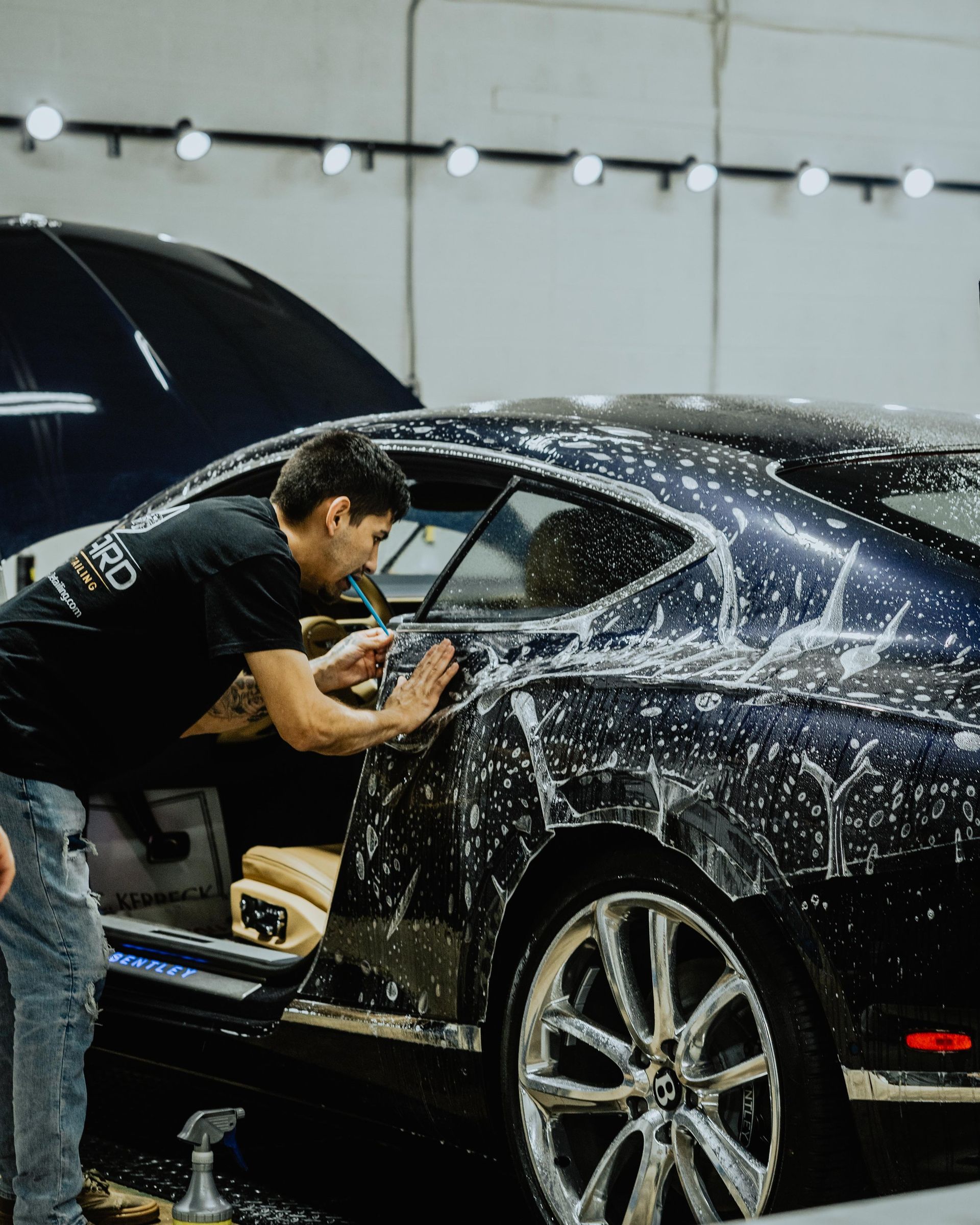 a man is washing a car in a garage .