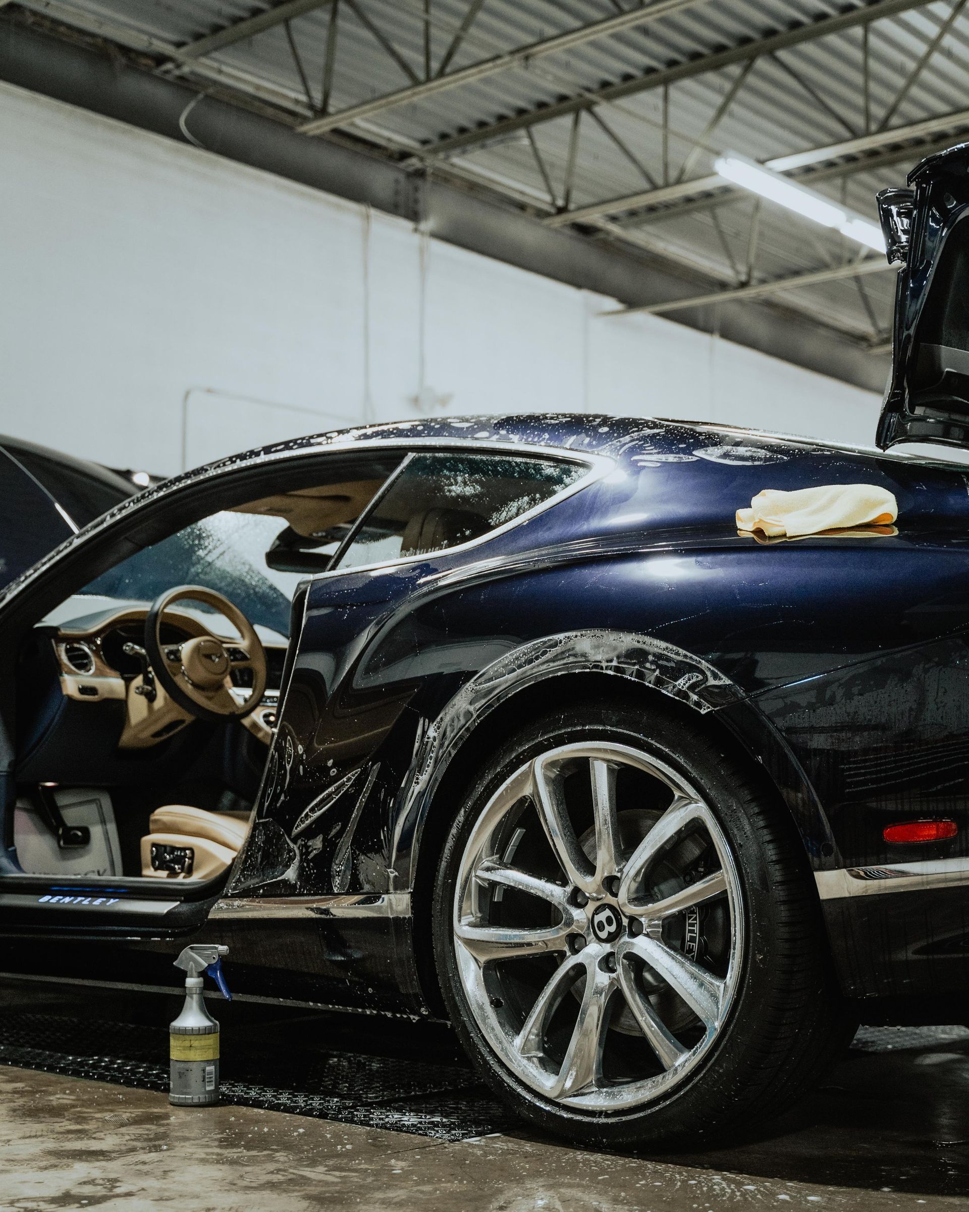 a blue sports car is being washed in a garage .tesla 