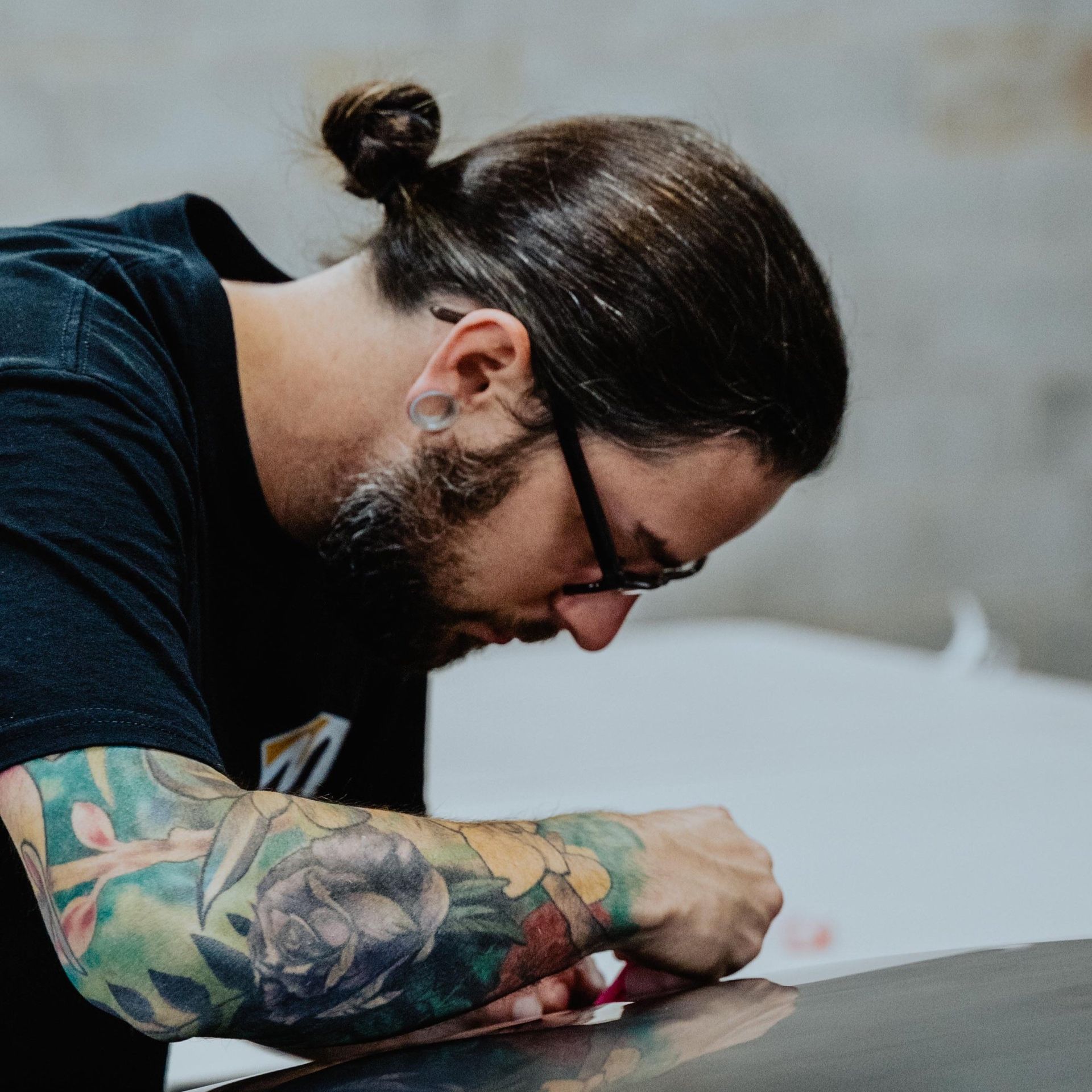 a man with tattoos on his arms is working on a car