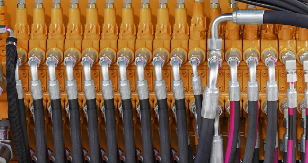 A Bunch Of Hydraulic Hoses Are Hanging On A Wall — HI PSI Hydraulics in Forster, NSW