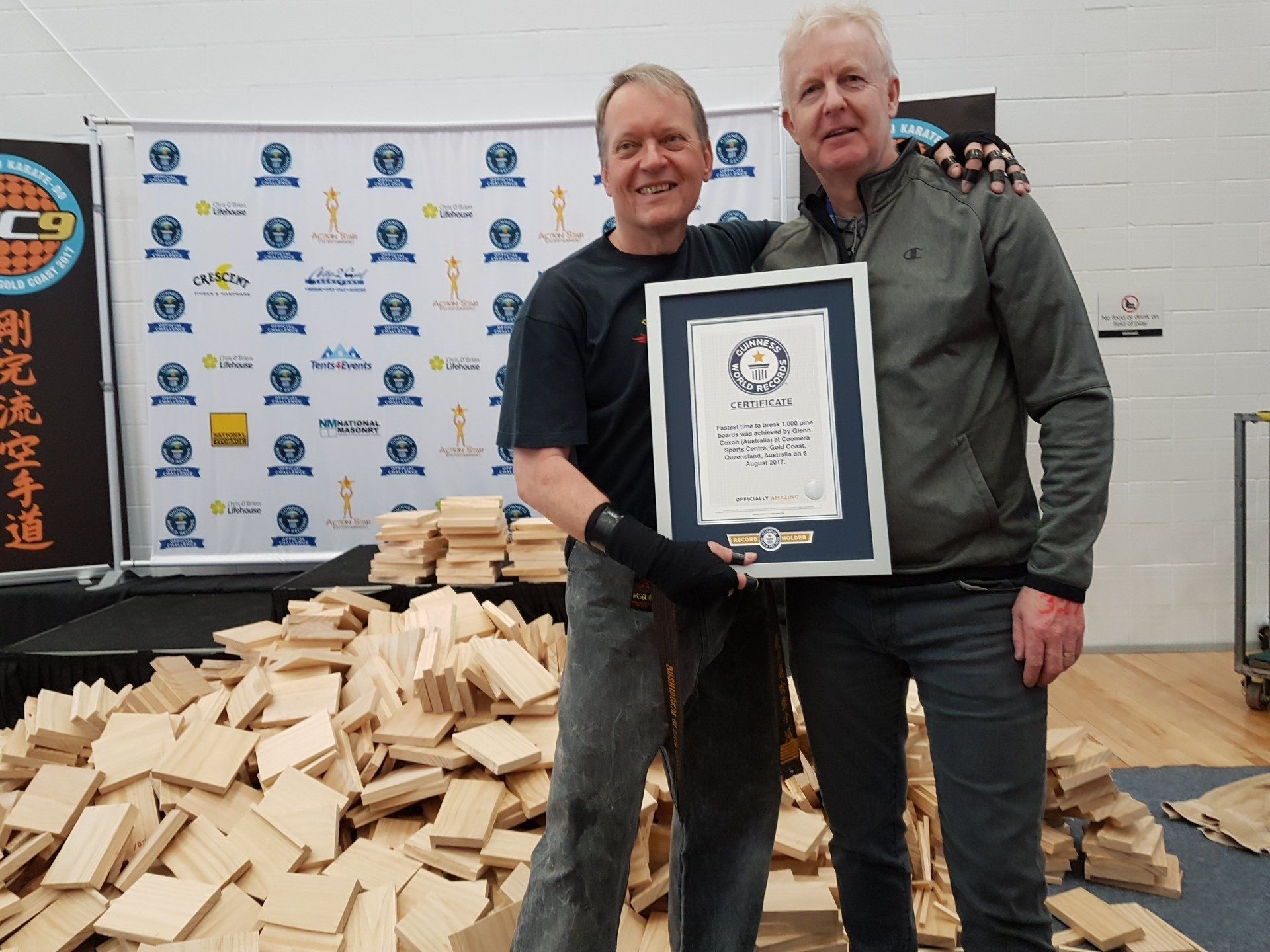 Two men standing next to each other holding a certificate