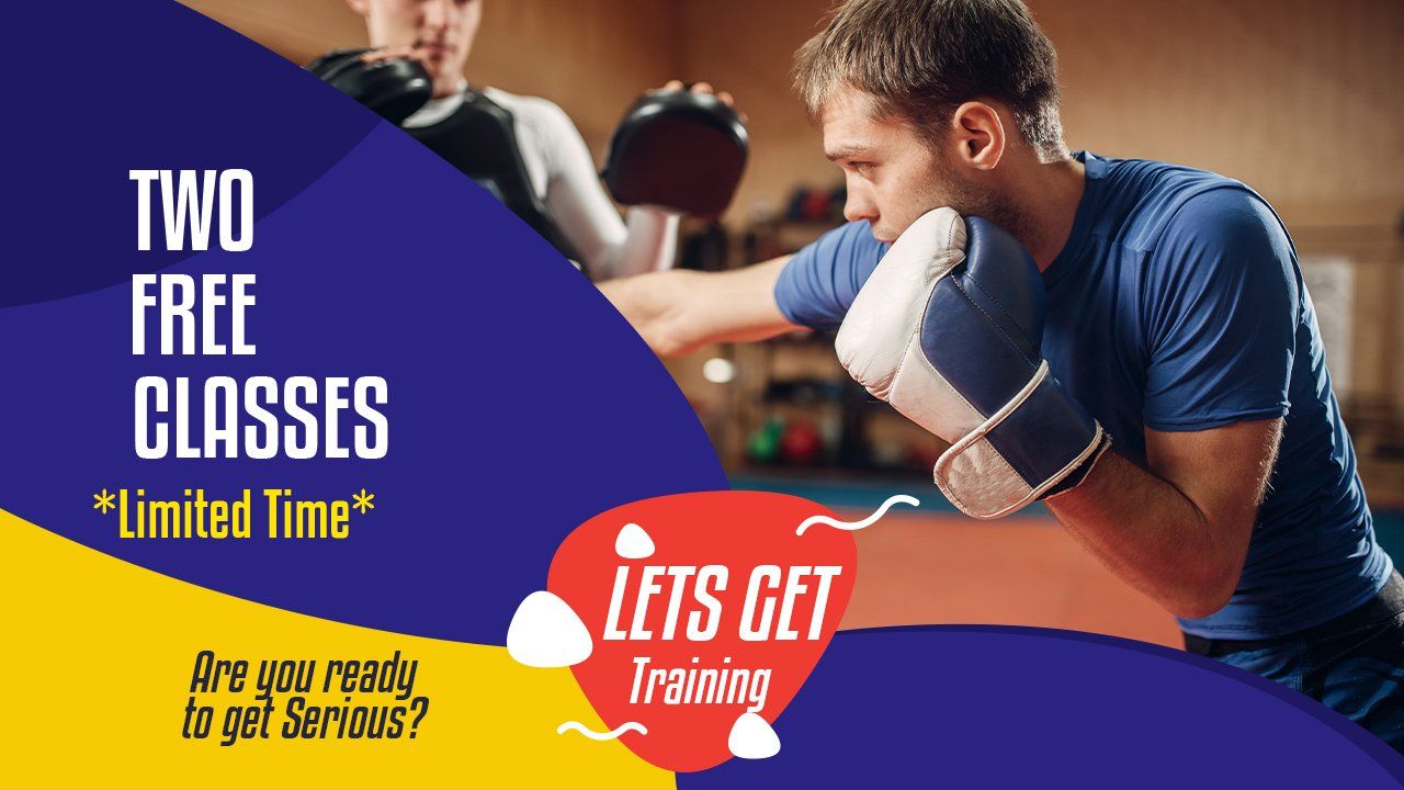 A man wearing boxing gloves is boxing another man in a gym.
