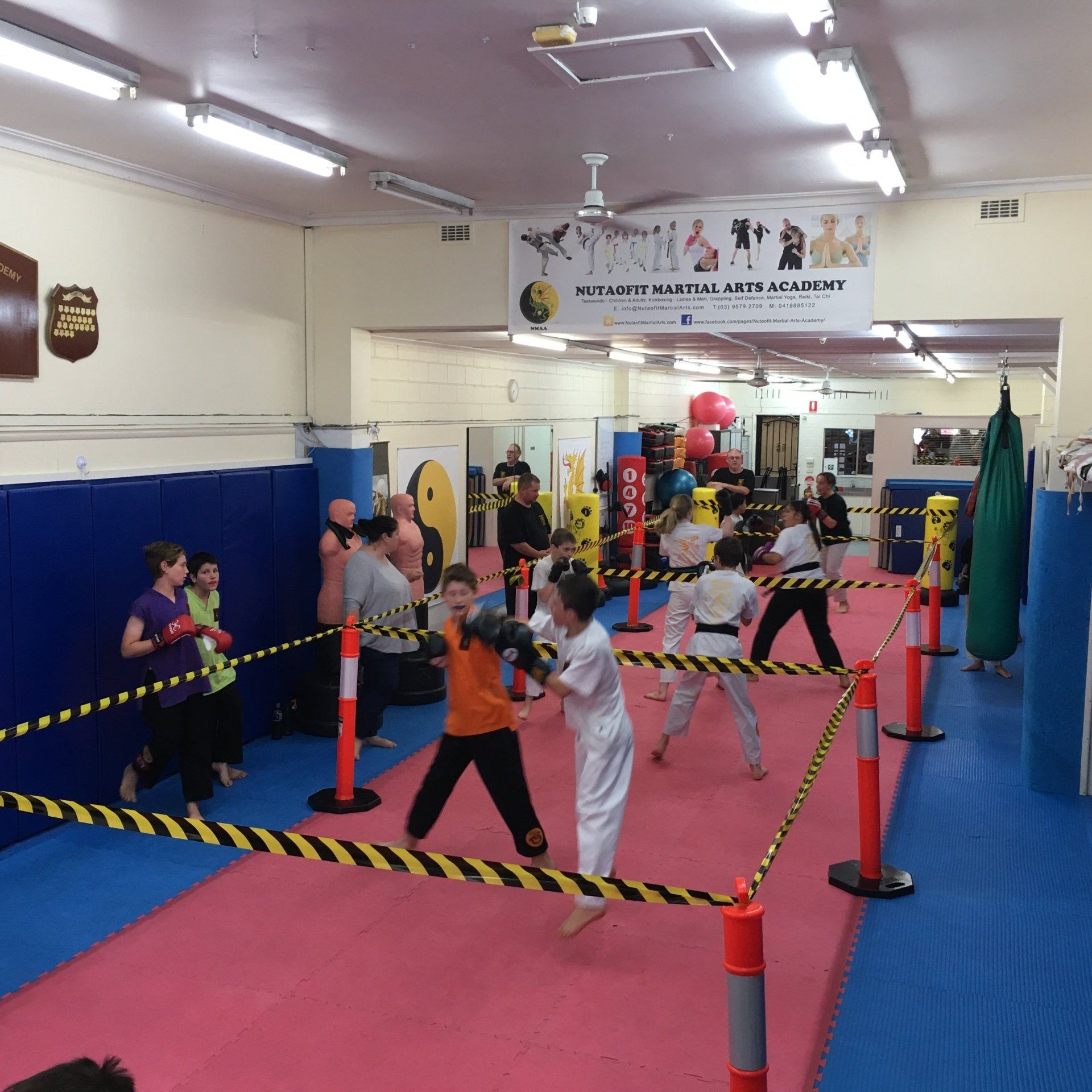 A group of kids are practicing martial arts in a gym