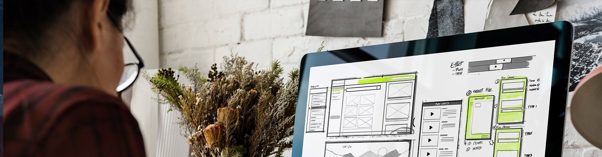 A woman is looking at a floor plan on a computer screen.