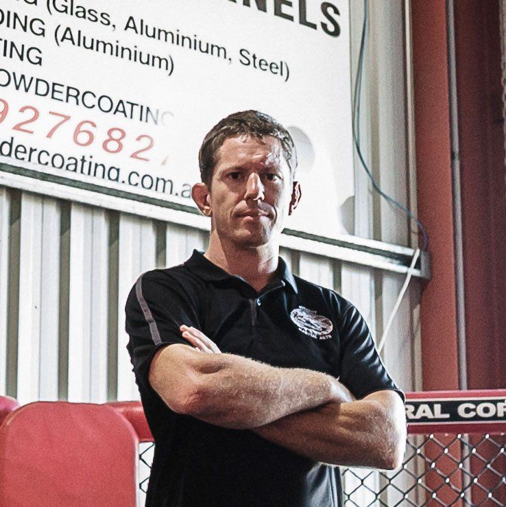 A man stands in front of a sign that says powdercoating