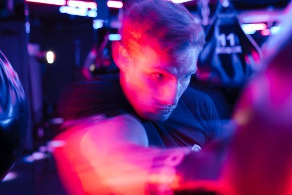 A man is playing a video game in a dark room.
