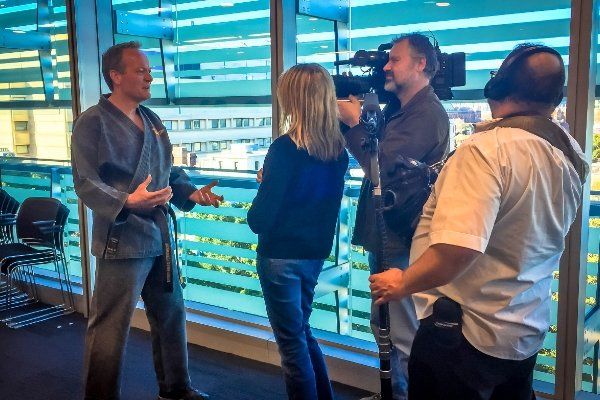 A group of people are standing in front of a camera talking to each other