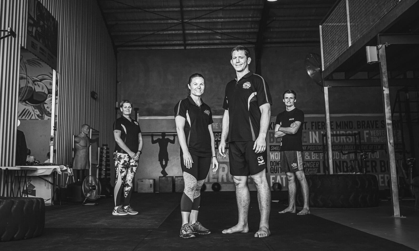 A black and white photo of a group of people standing in a gym.