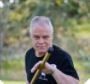 A man in a black shirt is holding a cane in his hand.