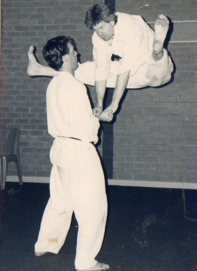 A black and white photo of two men practising martial arts